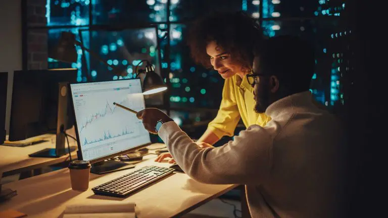 Two people looking at a graph on a computer