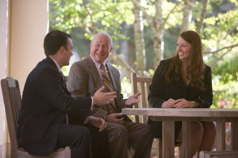 Three people talking around a table