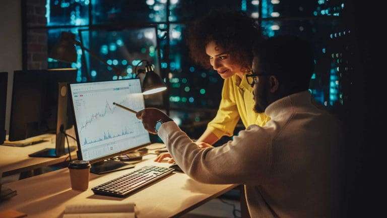 Two people looking at a graph on a computer