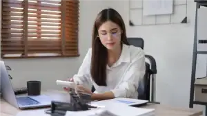 Person working on a laptop and calculator