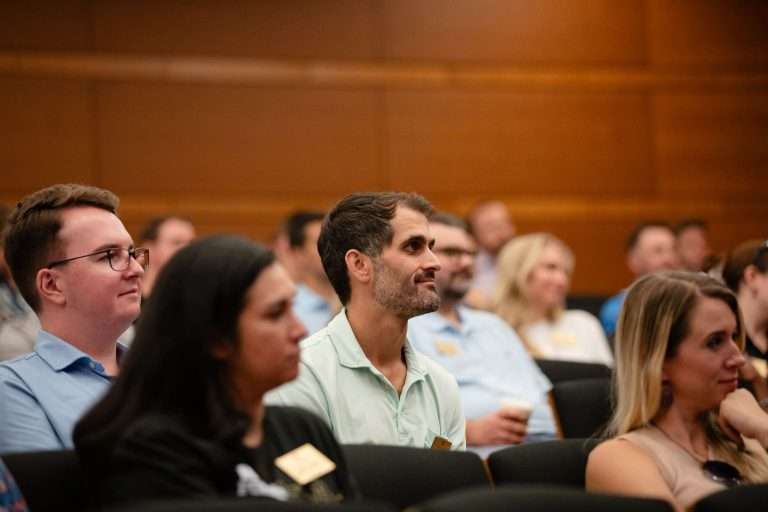 Close up photo of an audience looking forward.