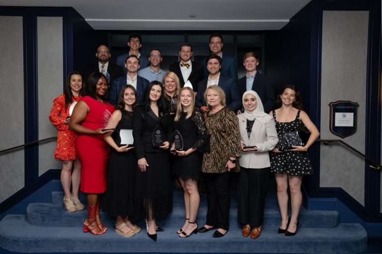 Business Graduates Posing, holding their awards for group photo.