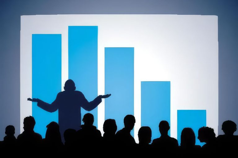 A presenter standing in front of a giant bar graph shrugging his shoulders to signal ignorance