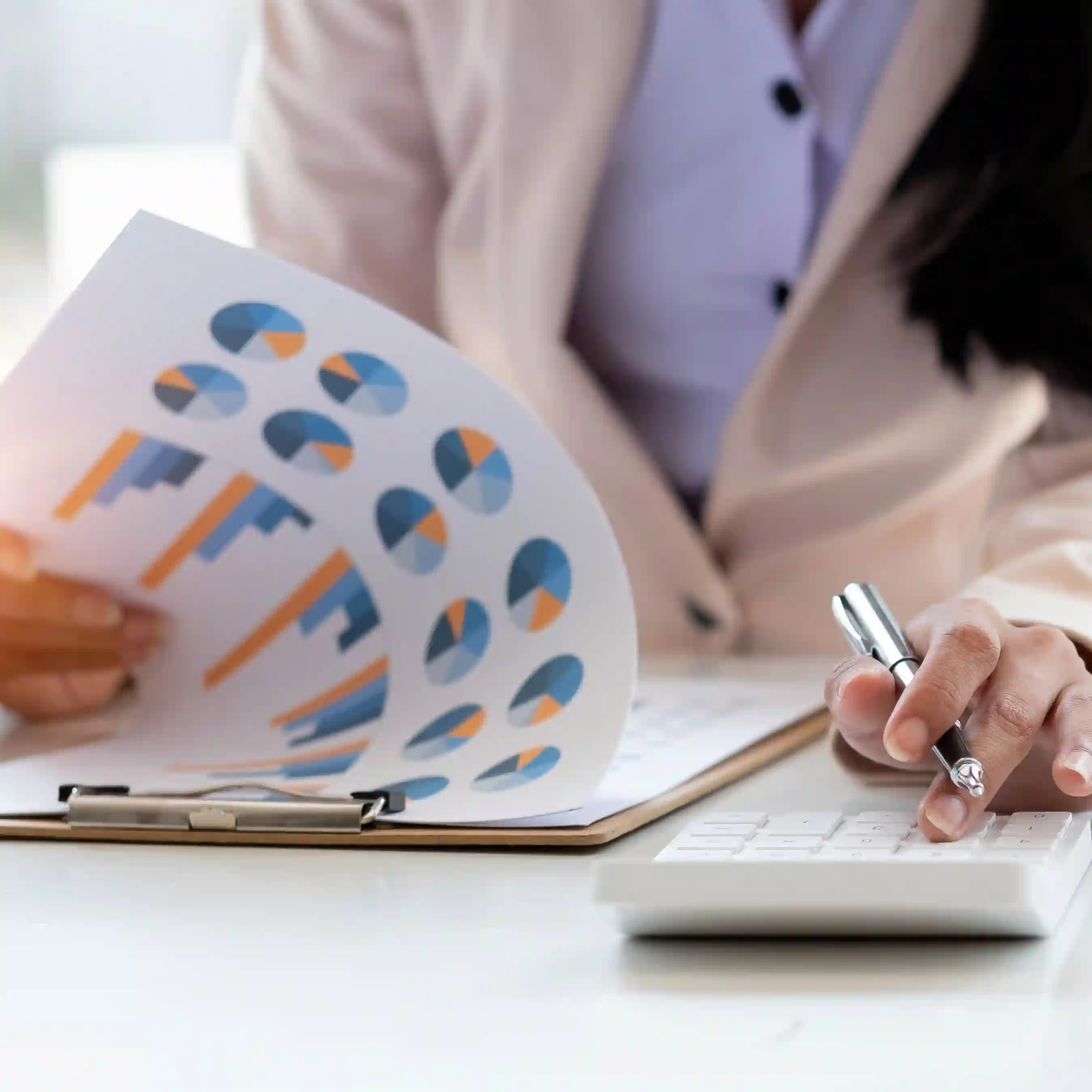 A cropped photo of a woman reviewing a set of data in the midst of her business analytics review.